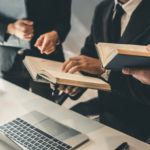 attorneys meeting in office in front of computer at desk