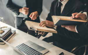 attorneys meeting in office in front of computer at desk